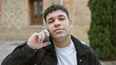 Şehir merkezinde cep telefonu kullanan yakışıklı bir adam.