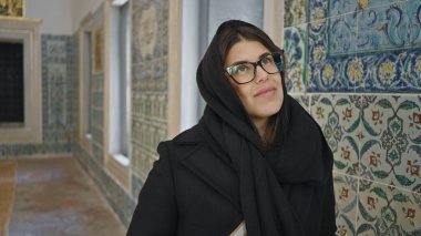 Gözlüklü düşünceli bir kadın İstanbul 'un Topkapı Sarayı' ndaki tarihi döşemelere hayran..