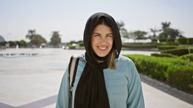 Abu Dabi 'deki İslami bir bahçede tesettürlü genç bir kadın duruyor..