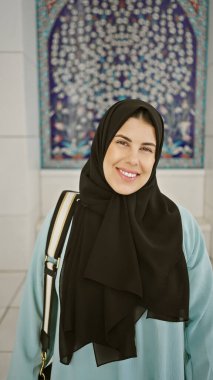 Abu Dabi 'de İslami camide poz veren tesettürlü genç bir kadın kültürel turizmi sembolize ediyor..