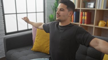 Modern bir oturma odasında esneyen yakışıklı İspanyol bir adam..