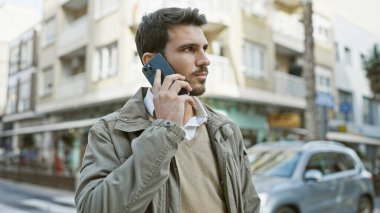 Meşgul şehirde akıllı telefondan konuşan yakışıklı İspanyol..