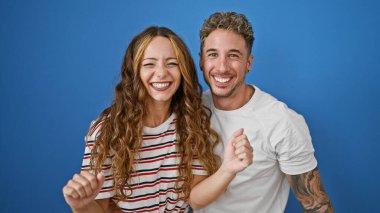 Mavi arka planda birlikte gülen mutlu bir çift..