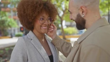 Çok kültürlü bir çift, bir şehir parkında neşe ve bağlantıyı kucaklayan hassas anları paylaşıyor..