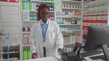 Modern bir eczanede ilaç düzenleyen profesyonel bir Afrikalı kadın eczacı..