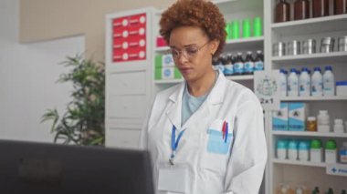 Şüpheci Afro-Amerikan kadın eczacı, ağzı açık, eczane üniforması içinde alaycı bakışlar.