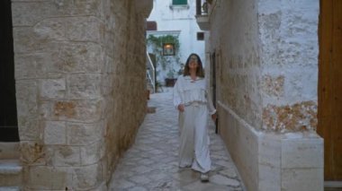 Genç bir İspanyol kadın polignano 'nun büyüleyici taş sokaklarında yürüyor. Bir kısrak, puglia, İtalya, gülümsüyor. Avrupa' nın pitoresk köyünü keşfederken..