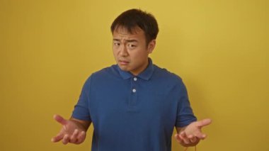 Sarı arka planda şüphe ve belirsizlik gösteren cahil ve kafası karışmış genç Çinli bir adam.