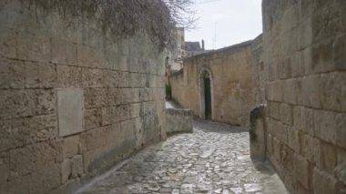 Materyalde, bazilikada, İtalya 'da taş duvarların, antik mimarinin, kaldırım taşının yollarının, güneşli bir gökyüzünün altında yalnız bir insanın, kapıların ve uzak binaların bulunduğu sakin bir ara sokak..