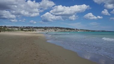 Salento, Puglia 'daki pescoluse plajının manzarası açık mavi gökyüzü, kumlu sahil ve turkuaz deniz..