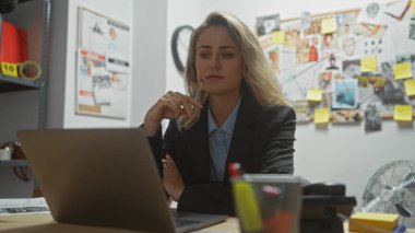 Düşünceli sarışın kadın dedektif ofis düzenindeki delilleri analiz ediyor.