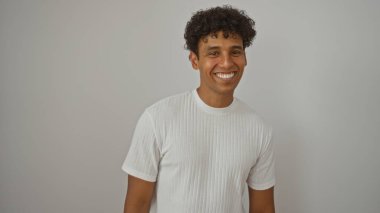 Yakışıklı İspanyol genç adam, izole edilmiş beyaz bir arka plana güvenerek gülümsüyor.