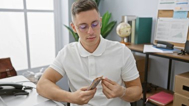 Bir ofis ortamında Meksika pezosu sayan genç bir İspanyol, odaklanmış ve profesyonel görünüyor..