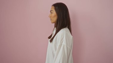 Genç, çekici, İspanyol, beyaz gömlek giyen, soyutlanmış, pembe, sakin bir yüzü ve esmer saçı olan bir kadın.