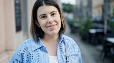 Viyana sokaklarında kendine güvenen güzel İspanyol kadın gülümsüyor.