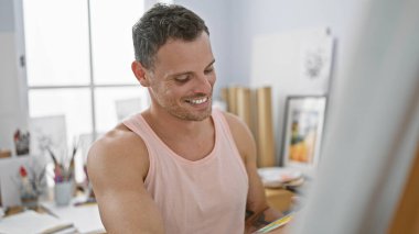 Stüdyoda sakallı, gülümseyen genç İspanyol adam yaratıcı profesyonel titreşimler yayıyor..