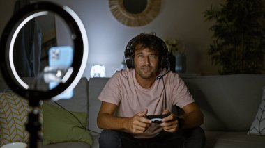 Yakışıklı İspanyol adam geceleri rahat bir oturma odasından video oyunları seyrediyor.