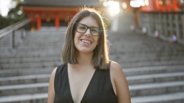 Fushimi inari-taisha 'da poz veren güzel İspanyol bir kadın. Başarılı gülümsemesinden neşe saçıyor. Kyoto' nun büyük tapınağında kendine güveni çarpıcı bir şekilde duruyor.
