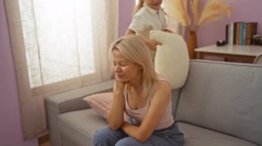 Anne ve kızı rahat bir oturma odasında yastıkla şakalaşıyorlardı. Aile bağlarını ve ev eğlencelerini ön plana çıkarıyorlardı..