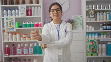 Onaylamayan eczacı, üniformalı genç İspanyol kadın eczanede kızgın bir ifadeyle baş parmak işareti gösteriyor, reddedilmeyi ve olumsuz geri bildirimi vurguluyor.
