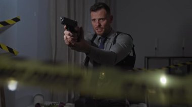 Ön planda bulanık bant ile cinayet mahalline silah doğrultan kararlı bir adam..