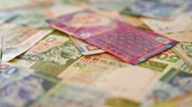 Renkli Hong Kong dolar banknotlarının kapatılması, çeşitli mezhepleri ve karmaşık tasarımları canlı, ayrıntılı bir şablon içinde sergiliyor.