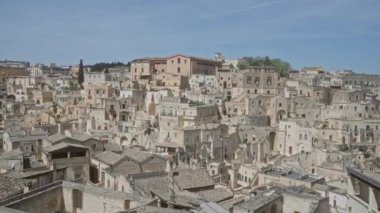 Parlak güneşli bir günde Materya, Basilicata, İtalya 'daki geleneksel taş evlerin çarpıcı panoramik manzarası.