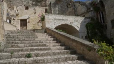 Materya, bazilika, İtalya 'daki antik taş merdivenler aşırı gelişmiş yeşillik ve saksı bitkilerinin bulunduğu kemerli bir kapıya açılıyor..