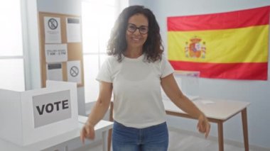 Oy verin, orta yaşlı İspanyol kadın oy pusulasıyla kendini gösteriyor. İspanya seçim kuruluna gururla bakıyor, mutlu ve kararlı görünüyor.