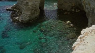 Torre dell 'orso, Salento, Puglia, İtalya' da kristal berraklığında turkuaz suyla sersemletici sahil kayalıkları ve güzel bir açık hava manzarası olan doğal kaya oluşumları..