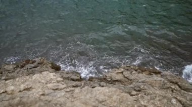 Cala Deia, Mallorca 'daki okyanus dalgalarına tepeden bakan kayalık uçurum kenarı, berrak turkuaz suları ve pürüzsüz kaya dokularıyla engebeli kıyı manzarasını yakalıyor..