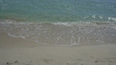 Sakin turkuaz dalgalar Porto sezaryen, puglia, İtalya 'da kumlu kıyılarda nazikçe tur atarak, doğa ve seyahat meraklıları için mükemmel sakin bir plaj sahnesi sağlar..