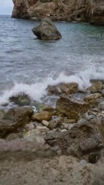 Kaya kıyısı Cala deia mallorca dalgaları kayalara çarpıyor. Manzaralı Akdeniz kıyısı manzarası.