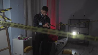 İspanyol dedektif evdeki suç mahallinde uyarı bandı ve ortam aydınlatmasıyla notlar alıyor..