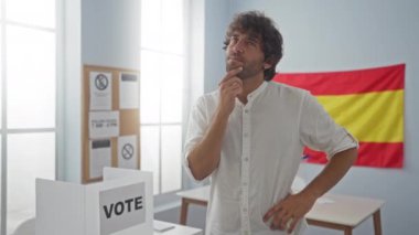 İspanyol asıllı genç bir adam, şaşkın bir yüzle tişört giyiyor, fikri işaret ediyor, mutlu, bir numara, İspanyol seçim okulunu sorguluyor.