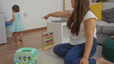 Oturma odasında oyuncak ve abaküs ile oynayan kadın ve bebek modern bir ev ortamında bir aile anı yaratıyor..