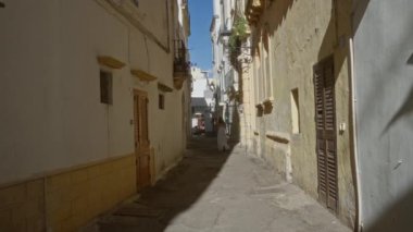 Gelibolu, puglia, italyan, geleneksel mimari ve büyüleyici atmosfer esansının bulunduğu dar bir sokakta yürüyen bir kadın..