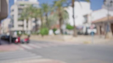 Arka planda arabalar ve palmiye ağaçları olan bulanık şehir manzarası. Bokeh etkisi var.