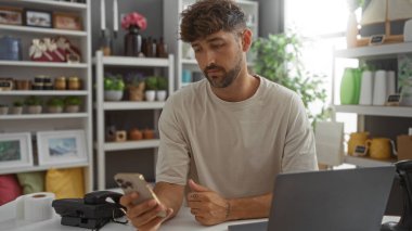 Ev dekorasyonu mağazasında, arka planda ürün ve bitki rafları olan güzel bir genç adam.