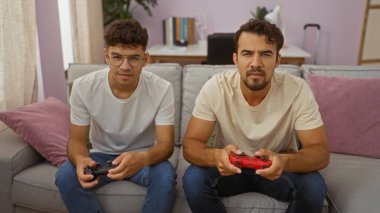 Baba ve oğul rahat bir oturma odasındaki kanepede birlikte video oyunları oynuyorlar. Kapalı bir evde iki İspanyol erkek arasındaki bağı, sevgiyi ve bağlantıyı sergiliyorlar..