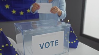 Avrupa Birliği bayraklarıyla süslenmiş bir odada oy veren Avrupalı kadın, yerel seçimlere demokratik katılımı simgeliyor.