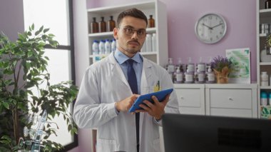 Eczanede sakallı, gözlüklü, laboratuvar önlüklü, elinde tablet olan yakışıklı bir İspanyol..