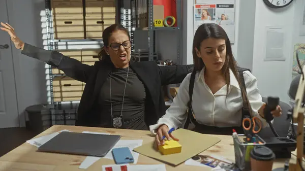 stock image Two women detectives in an office with a badge, evidence, frustration, files, and photos convey a crime investigation scene.