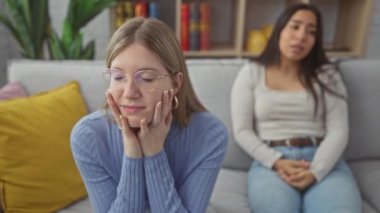 İki kadın, sıcak bir oturma odasında anlaşmazlıklarını dile getiriyorlar. Duygularını ve konuşmalarını gösteriyorlar..