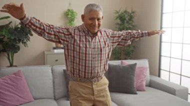 Yaşlı İspanyol bir adam oturma odasında keyifli bir an yaşıyor, ev dekoruyla çevrili, neşeli bir ev hayatı sergiliyor..