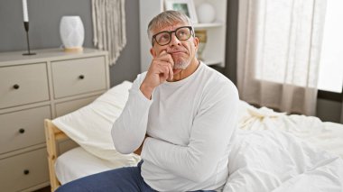 Modern bir yatak odasında, gözlüklü, düşünceli, son sınıf öğrencisi.