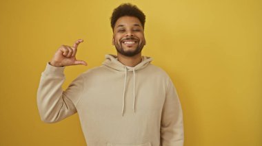 Gülümseyen Afrikalı Amerikalı adam sarı kapüşonlu adama küçük bir jest yapıyor.