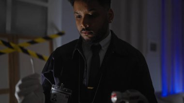 Kapalı alanda dedektiflik yapan Afrikalı Amerikalı bir adam suç mahalli kanıtlarını analiz ediyor, ciddiyet yayıyor ve odaklanıyor..