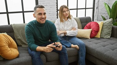 Modern bir oturma odasında oyun arkadaşından memnun olmayan bir kadın.