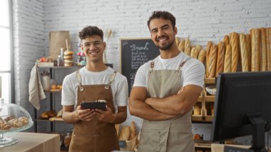 Ekmek ve fırın ürünleriyle çevrili bir fırının içinde fırıncı olarak yan yana duran erkek işçiler.